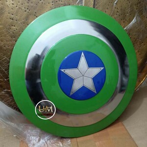 Op de afbeelding: Een groen Captain America schild met een zilveren rand en een blauwe ster in het midden. De ster heeft een witte omtrek en een zilveren centrum.