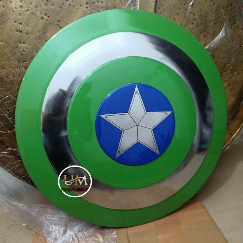 Op de afbeelding: Een groen Captain America schild met een zilveren rand en een blauwe ster in het midden. De ster heeft een witte omtrek en een zilveren centrum.