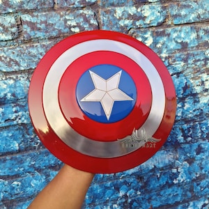 May include: A red, white and blue Captain America shield with a silver metal rim. The shield has a five-pointed star in the centre.