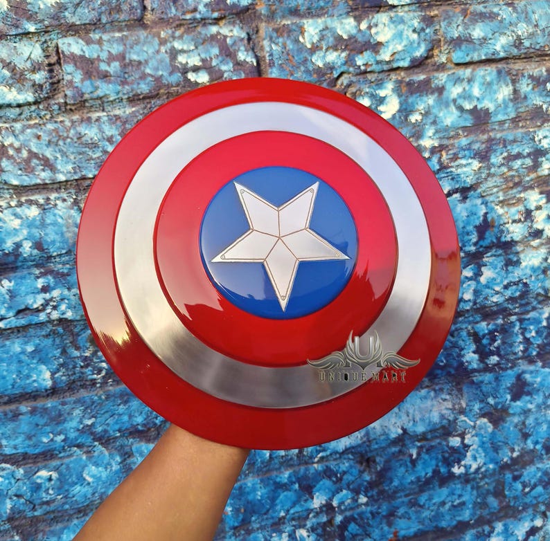 May include: A red, white and blue Captain America shield with a silver metal rim. The shield has a five-pointed star in the centre.