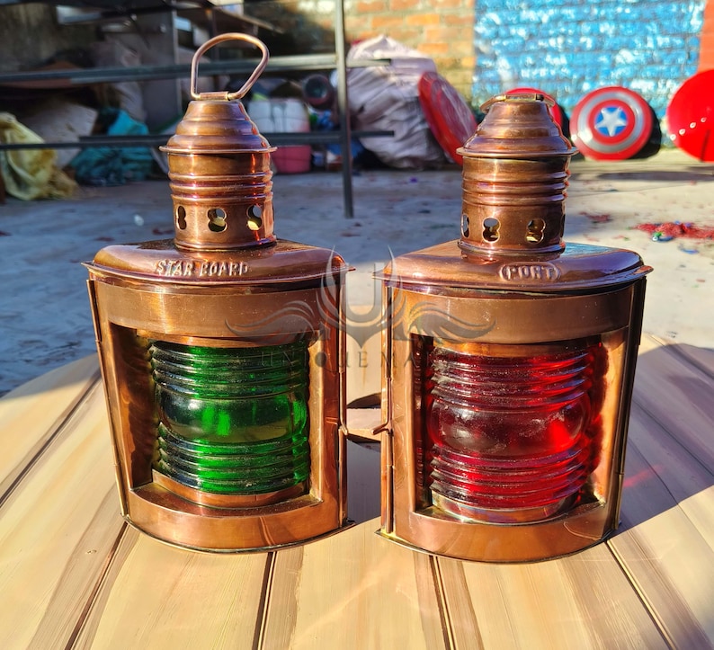 Pu&ograve; includere: Due lampade di segnalazione nautiche antiche in rame con lenti in vetro. La lampada a sinistra ha una lente verde e dice "Dritto" sul lato. La lampada a destra ha una lente rossa e dice "Sinistro" sul lato.