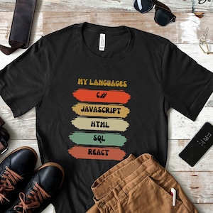 May include: Black t-shirt with the text "My Languages" and a list of programming languages in colorful retro-style boxes: C#, Javascript, HTML, SQL, React.