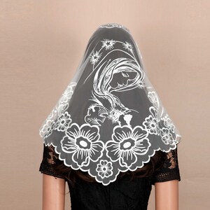 May include: White lace veil with a floral design and an image of the Virgin Mary and baby Jesus.