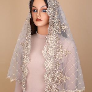May include: A sheer white veil with gold embroidery. The veil has a scalloped edge and a delicate floral pattern.