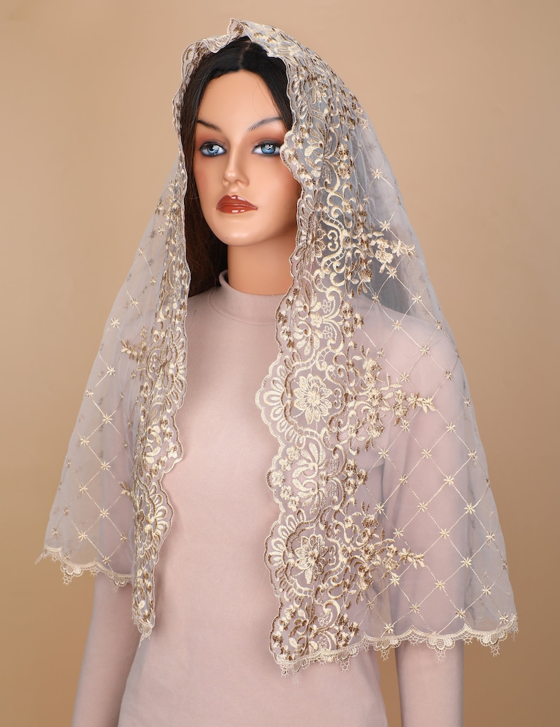 May include: A sheer white veil with gold embroidery. The veil has a scalloped edge and a delicate floral pattern.