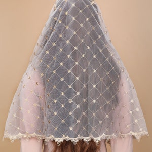 May include: A white sheer veil with gold embroidered stars in a diamond pattern. The veil has a scalloped lace trim.