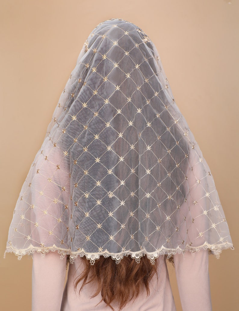 May include: A white sheer veil with gold embroidered stars in a diamond pattern. The veil has a scalloped lace trim.