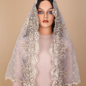 May include: A sheer, light grey veil with gold embroidery. The veil has a scalloped edge and a delicate floral pattern.
