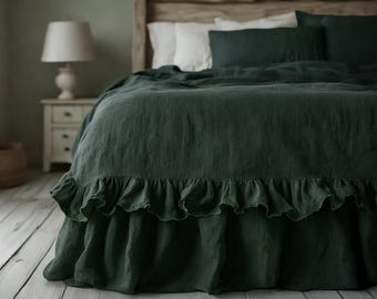 May include: A bed with dark green bedding, including a ruffled bed skirt. The bed has white pillows and a dark green duvet cover. The headboard is made of light-coloured wood. The room has a neutral colour palette.