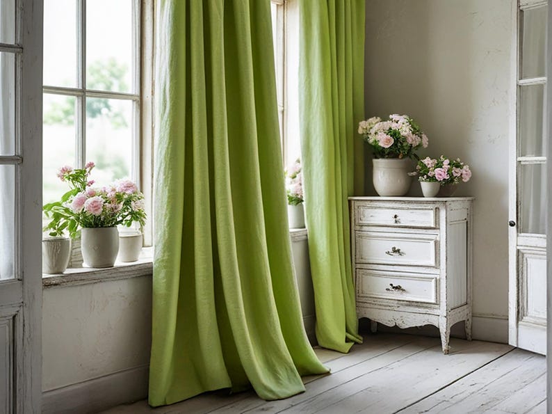 May include: Lime green linen curtains frame a window with a view of the outdoors. Pink roses in white ceramic pots sit on the windowsill. A white distressed chest of drawers holds more pink roses, creating a bright and airy interior design.