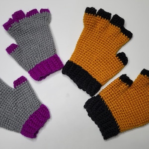 May include: Two pairs of fingerless gloves. One pair is grey with purple trim, the other is orange with black trim.