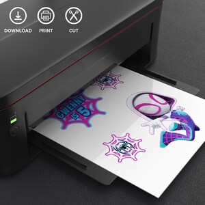 May include: A printer is shown with a sheet of paper featuring a cartoon character and the text "GWENNY IS 5". The character is wearing a white and pink mask and a blue and purple suit. The paper also has spiderweb designs.