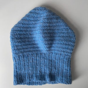 Puede incluir: Un gorro de punto azul con borde de canal&eacute;.