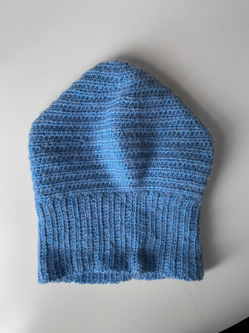 Puede incluir: Un gorro de punto azul con borde de canal&eacute;.