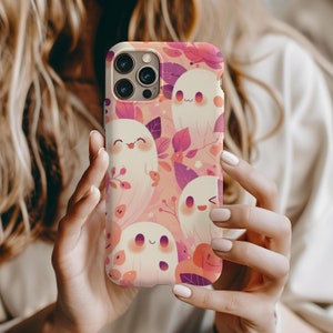 Könnte beinhalten: Eine rosa und lila Handyhülle mit einem Muster aus weißen Geistern und Blättern. Die Hülle ist für ein iPhone 13 Pro Max konzipiert.