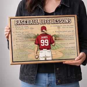 May include: A rectangular wooden sign titled BASEBALL LIFE LESSONS featuring an illustration of a baseball player in a red jersey with the name JAMES and number 99 on the back, holding a bat and ball, surrounded by twelve numbered life lessons.