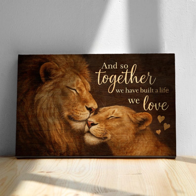 May include: A wood-grain background with a couple of lions cuddling. The text reads "And so together we have built a life we love" with gold hearts.
