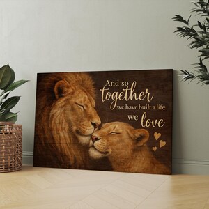 May include: A wood-grain background with a lion and lioness cuddling. The text reads "And so together we have built a life we love" with small hearts around the text.
