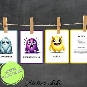 May include: A set of colorful flash cards with cartoon monster illustrations representing different emotions. The cards are held by wooden clothespins on a string against a dark background. The text "BONUS FLASH CARDS" is also visible.