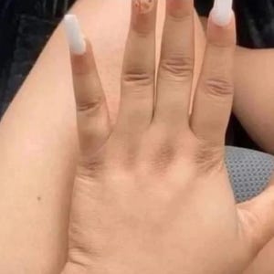 May include: A hand with long, white acrylic nails. The nails are square-shaped and extend past the fingertips. The skin tone is light brown. The image shows the hand in a relaxed position, with the fingers slightly spread.