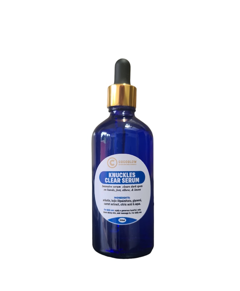 May include: A cobalt blue serum bottle with a gold dropper. The label reads "KNUCKLES CLEAR SERUM" and lists ingredients. The product is designed to clear dark spots on hands, feet, elbows, and knees. The bottle is filled with a clear liquid.