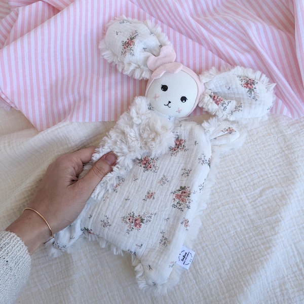 Mini doudou lapin avec bandeau papillon rose, tissu fleuri, personnalisable avec un prénom, en stock et disponible à l'adoption