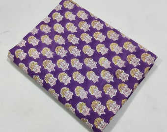 May include: Purple cotton fabric with a white and yellow floral print. The fabric is folded in half and has a textured surface.