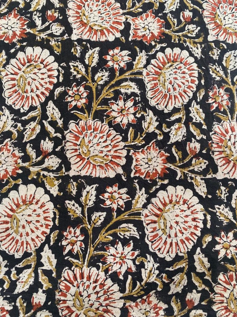 May include: Black fabric with a repeating floral pattern. The flowers are red, white, and cream with a brown outline. The background is black.