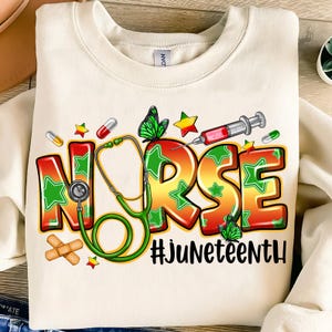以下が含まれることがあります： クリーム色のスウェットシャツにカラフルなグラフィック。 「NURSE」の文字が、緑色の星のアクセントで大きく太字で表示されています。 緑色の聴診器、蝶、ピル、注射器も特徴です。 テキスト「#Juneteenth」が下にあります。
