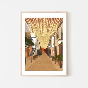 May include: A narrow, cobblestone street lined with buildings, decorated with twinkling string lights overhead. The street is empty, with a few potted plants and a sign that reads "Cafe" visible.