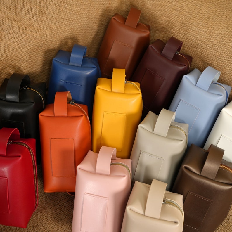 a group of different colored leather bags sitting next to each other