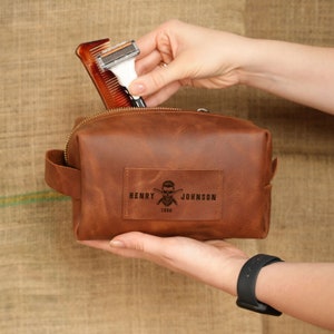 a person holding a leather pouch with a razor in it