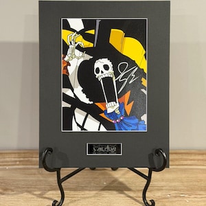 May include: A set of three ceramic mugs with a speckled, matte finish. The mugs are in shades of cream, light gray, and dark gray. Each mug has a simple, minimalist design and a rounded handle.