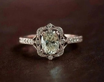 May include: A silver ring with an oval-shaped diamond set in a delicate, ornate filigree design.