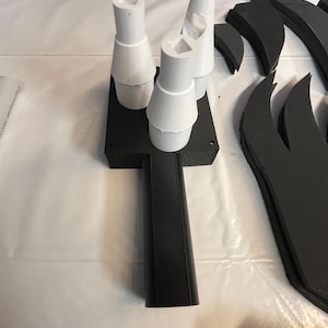 May include: Three white foam cones attached to a black foam base. The base has a long black handle.