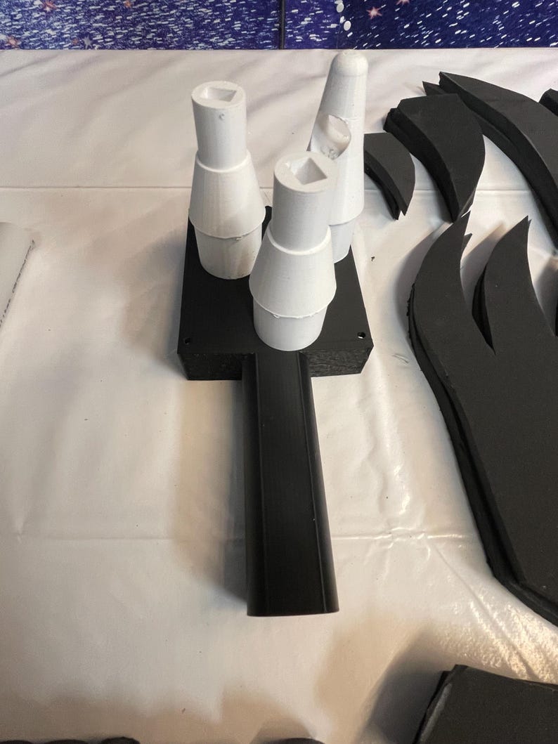May include: Three white foam cones attached to a black foam base. The base has a long black handle.