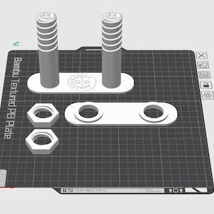 Peut inclure: Un assemblage imprimé en 3D de composants blancs, comprenant deux poteaux cylindriques avec des sommets striés, deux écrous hexagonaux et deux pièces avec des trous circulaires. Les pièces sont disposées sur une surface noire texturée avec le texte "Bambu Textured PEI Plate".