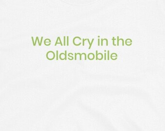 May include: White t-shirt with green text that reads "We All Cry in the Oldsmobile".