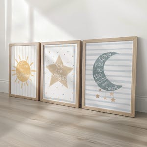 May include: Three framed art prints with inspirational quotes. The first print features a yellow sun with the text "You are my Sunshine" on a striped background. The second print has a star with the text "You are Magic". The third print has a moon with the text "Love you to the moon and back".