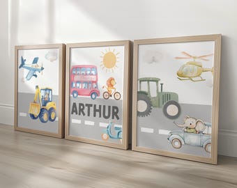 Puede incluir: Tres impresiones enmarcadas en acuarela con vehículos de transporte. Las impresiones incluyen una excavadora amarilla, un autobús de dos pisos rojo, un tractor verde, un avión azul, un helicóptero amarillo y una scooter azul. La impresión central tiene el nombre "ARTHUR".