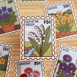 May include: A rectangular sticker shaped like a postage stamp featuring a Lily of the Valley illustration with white bell-shaped flowers, green leaves, and a blue stream. The text reads Lily of the Valley and 75c, surrounded by other floral stamp designs.