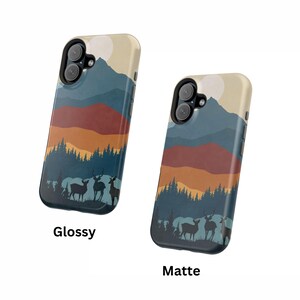 May include: Two phone cases featuring a mountain and deer silhouette design. The case on the left is glossy and the case on the right is matte.