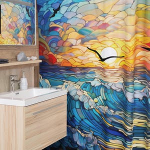 Puede incluir: Una cortina de ducha colorida con un dise&ntilde;o de vitral de una puesta de sol sobre el oc&eacute;ano. La cortina presenta colores azules, amarillos, naranjas y rojos, con p&aacute;jaros volando en el cielo.