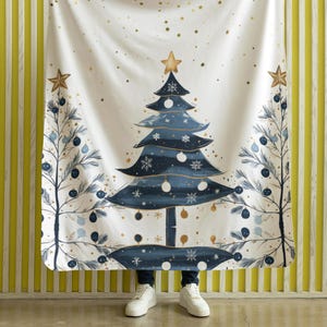 May include: A white fleece blanket with a blue and gold Christmas tree design. The tree is decorated with gold stars, blue ornaments, and white snowflakes. The blanket is perfect for adding a festive touch to your home decor.