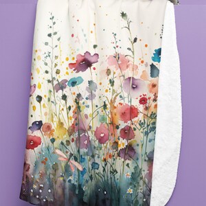 May include: A watercolor painting of a field of wildflowers in shades of pink, purple, red, yellow, and blue. The flowers are surrounded by green stems and leaves. A dragonfly is flying above the flowers.
