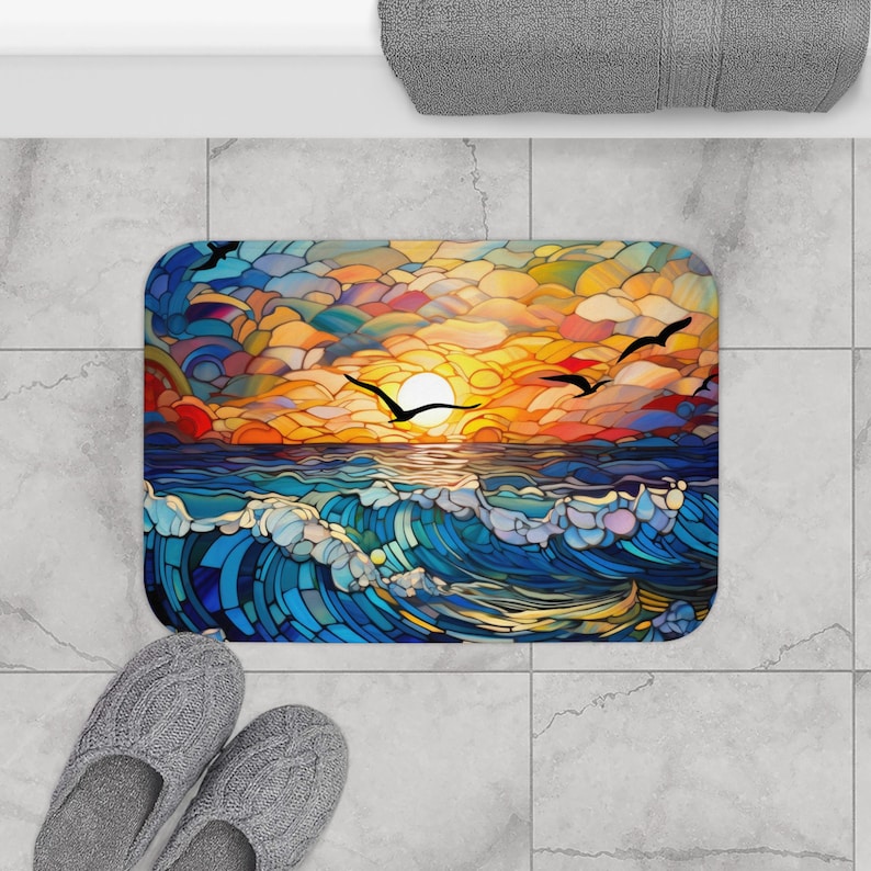 Puede incluir: Una colorida alfombra de ba&ntilde;o estilo vitral con una puesta de sol sobre el oc&eacute;ano y p&aacute;jaros volando en el cielo.