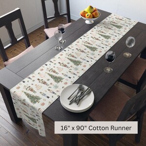 May include: A cotton table runner with a festive pattern of nutcrackers and Christmas trees. The runner is 16 inches wide and 90 inches long, displayed on a dark wood table set for a meal. Wine glasses and a plate with silverware are visible.