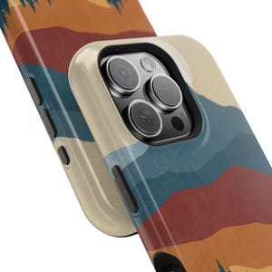 May include: A phone case featuring a colourful mountain landscape design. The case has a cut-out for the camera lens and a raised lip around the edges to protect the screen.