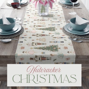 May include: A cream-colored table runner with a Nutcracker Christmas theme. The runner features a repeating pattern of nutcrackers, Christmas trees, and ballerinas. The text "Nutcracker CHRISTMAS" is displayed on the bottom of the image.
