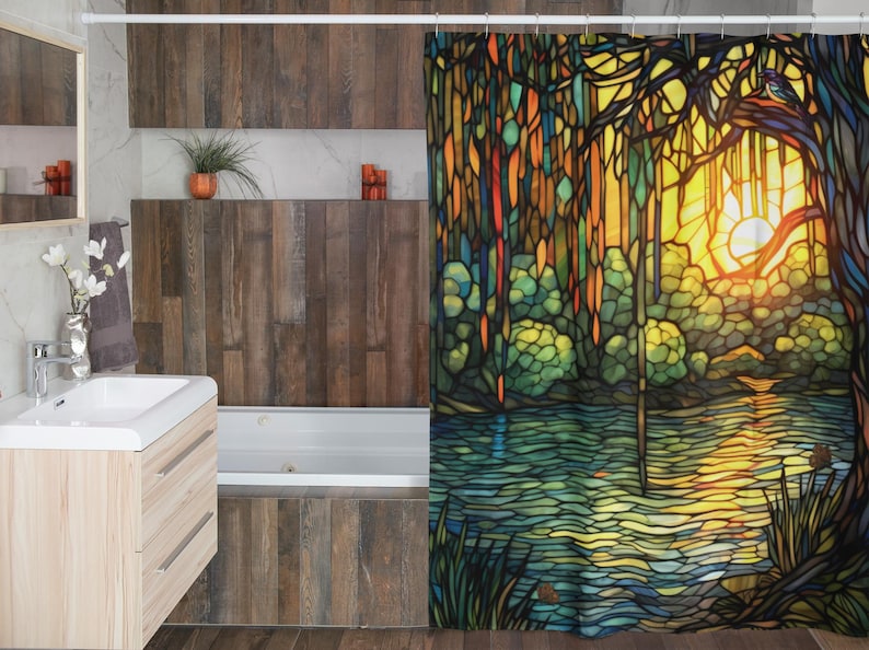 Puede incluir: Una cortina de ducha de vidrio coloreado que presenta una puesta de sol colorida sobre un lago con &aacute;rboles y un p&aacute;jaro en la esquina superior derecha.